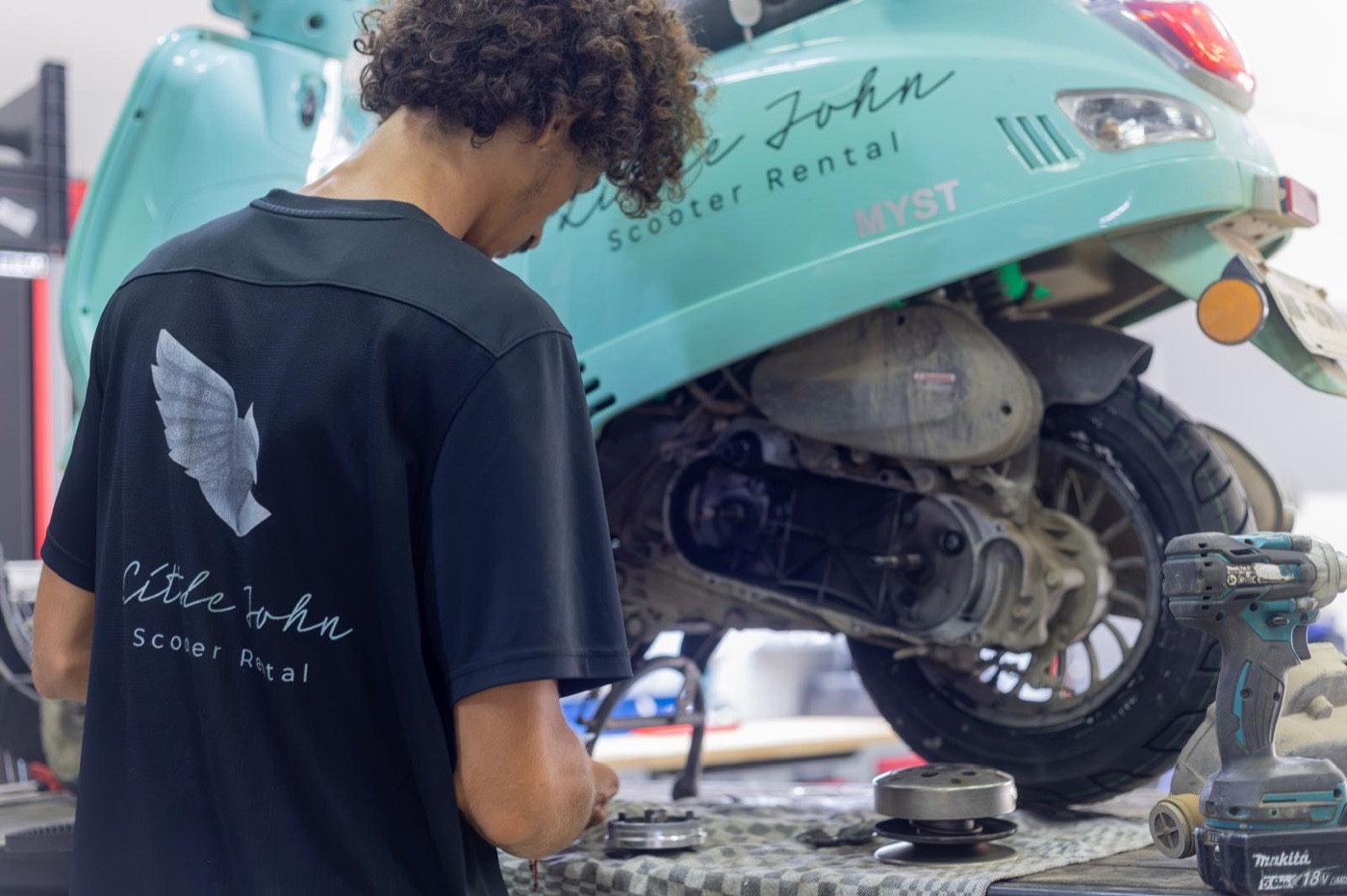 Little John mechanic in the eagle shirt working on a Myst scooter