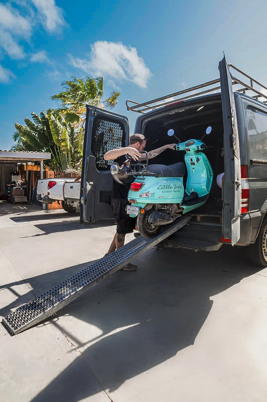 Rolling a scooter up the ramp into the Little John van for pickup